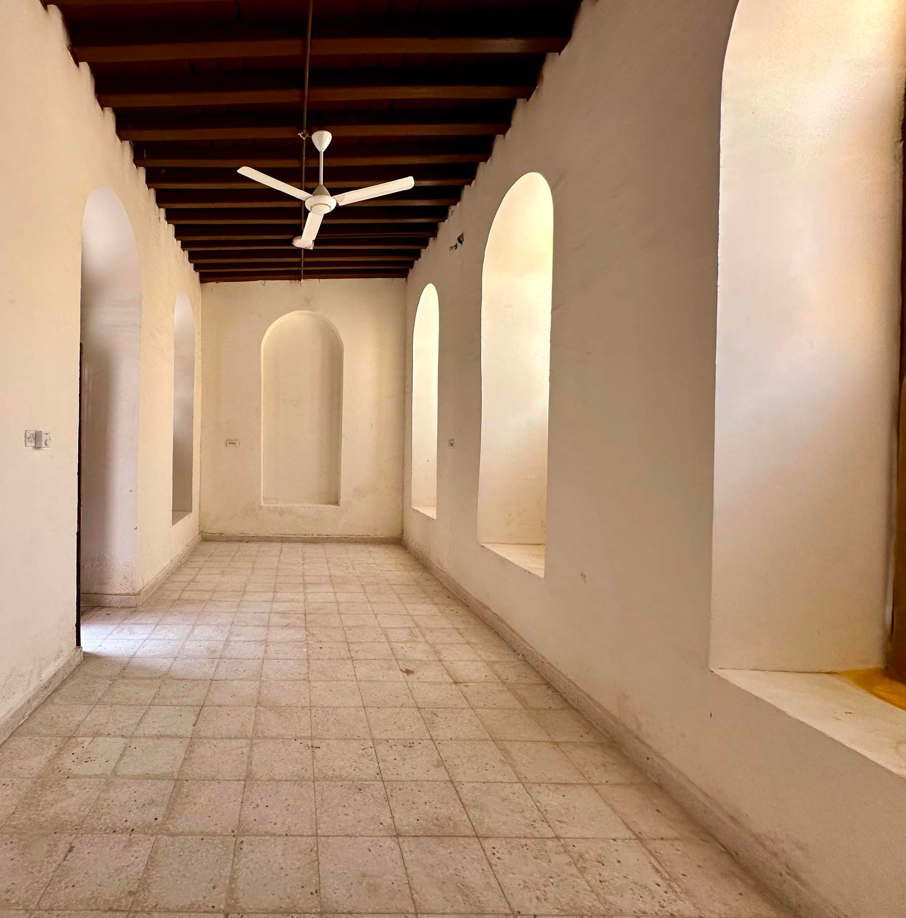 Restored corridor with arched openings and wooden ceiling